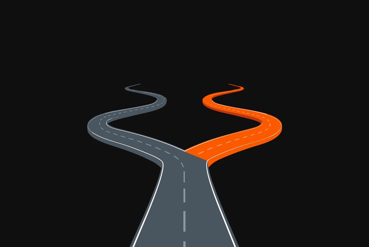 A road seen from above forking into two branches, one branch grey and the other orange.
