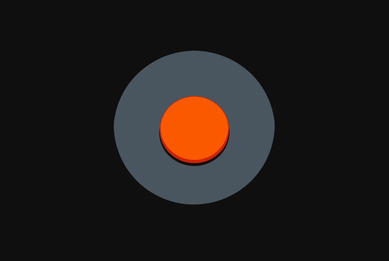 A large round push button on a grey base, the top of the button coloured orange.