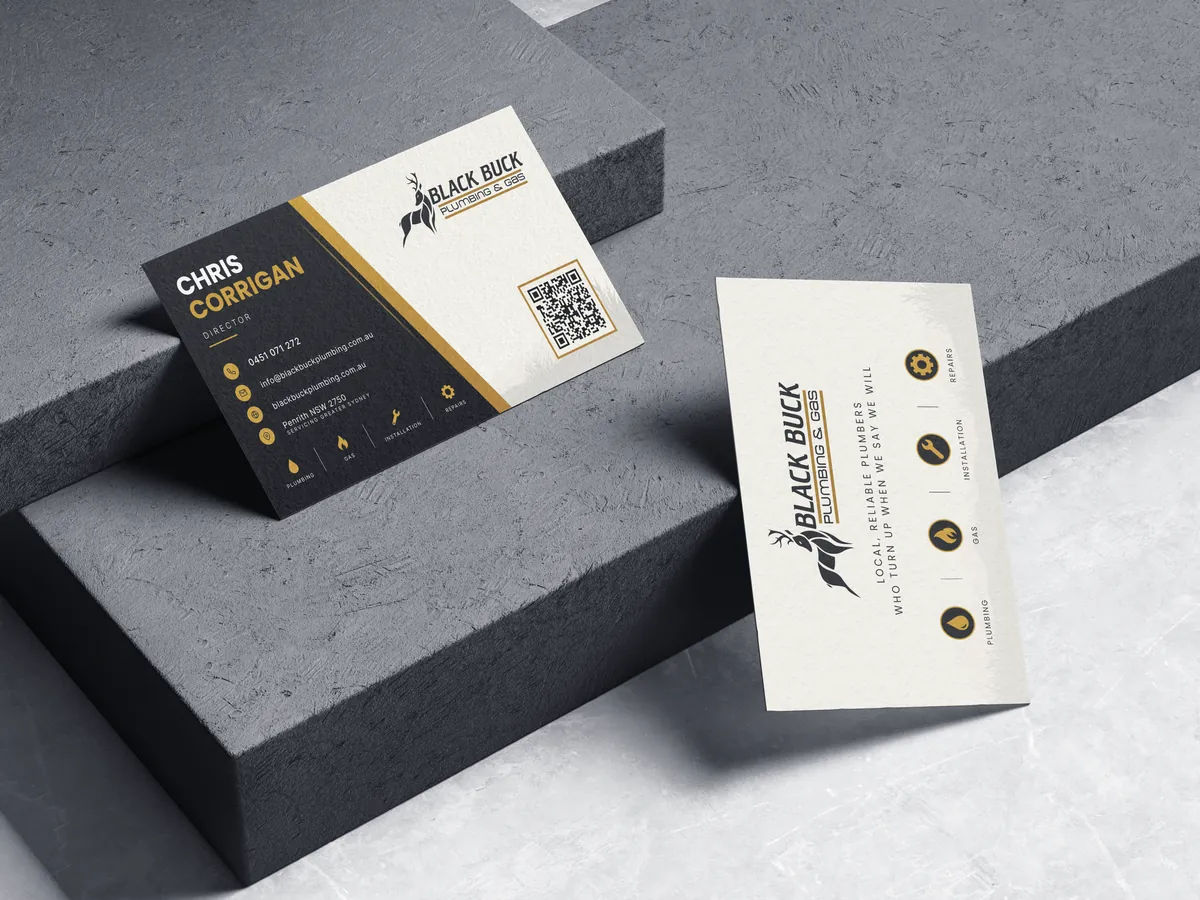 Example business card design for a Western Sydney plumbing and gas business, front and back, shown as a photo mockup on concrete steps.